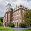 This photo shows a multistory, older-style brick building with a mansard roof on a former college campus in Montpelier, Vermont.