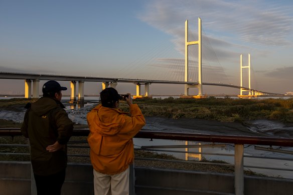Chinese tourists in Dandong take photos of the New Yalu River Bridge, connecting China and North Korea, which recently opened after a 12-year wait.