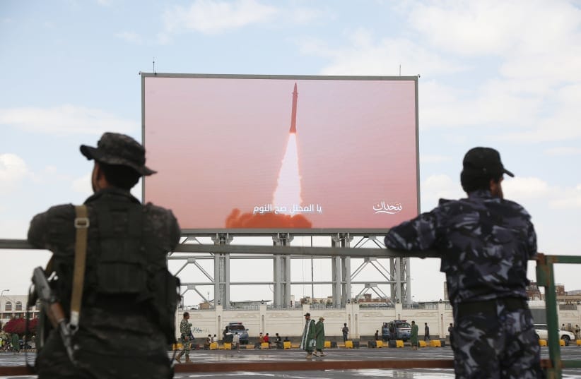 Yemeni security soldiers stand in front of a screen broadcasting Houthi-run forces launching a missile, during a demonstration staged to support missile forces in protecting the country's sovereignty and to denounce the Saudi accusation that Yemenis are attempting to attack Maca, on September 18.