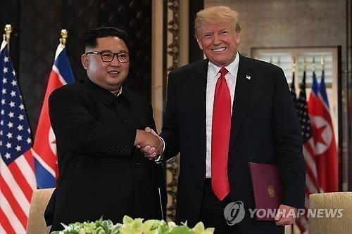 This AFP file photo shows U.S. President Donald Trump (R) shaking hands with North Korean leader Kim Jong-un after signing a joint statement at the Capella Hotel on Sentosa Island in Singapore on June 12, 2018. (Yonhap)