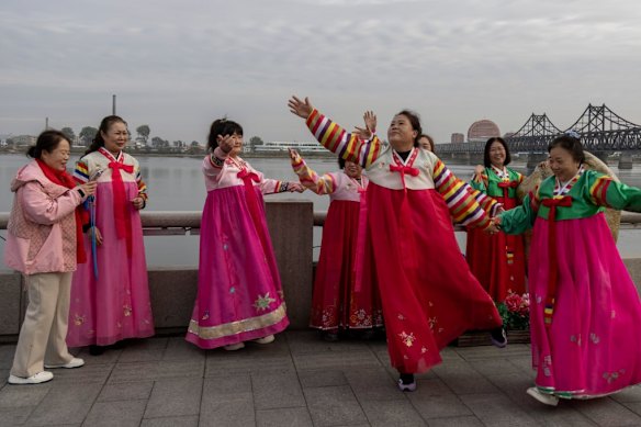 Chinese tourists wearing traditional Korean clothes sing revolutionary songs in Dandong.